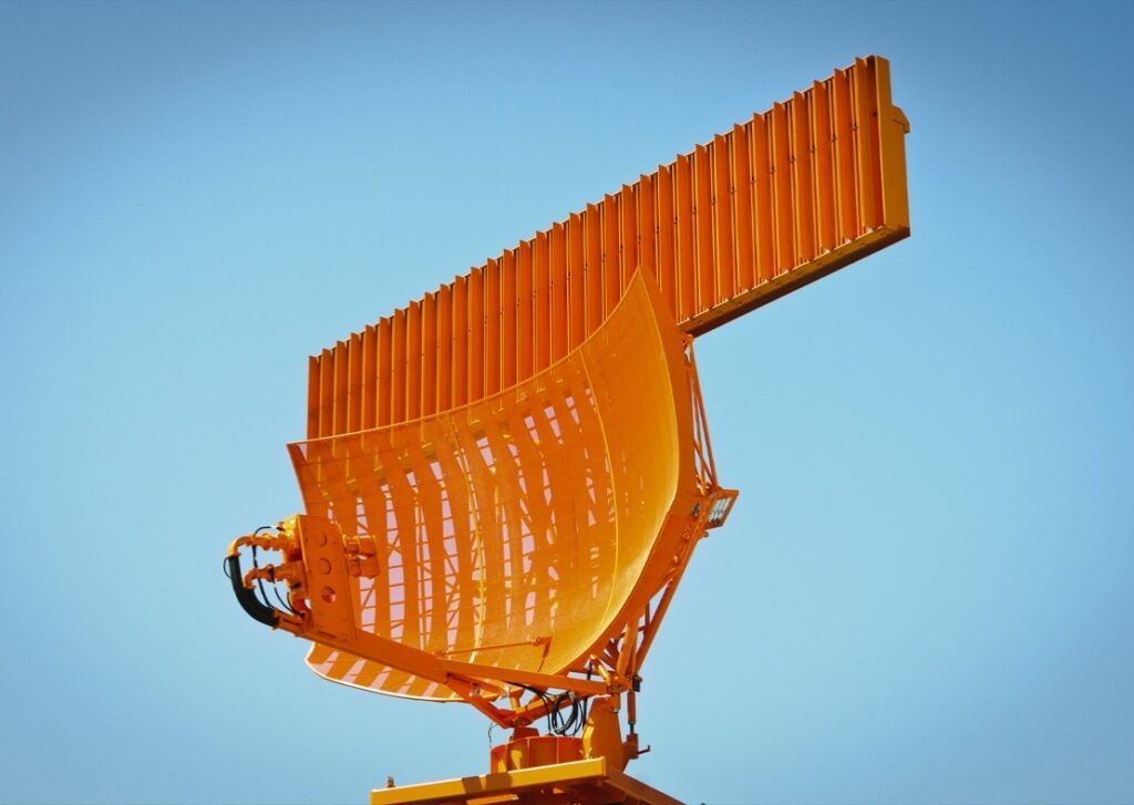 An orange Indra Group USA radar brightens up a blue, cloudless sky.
